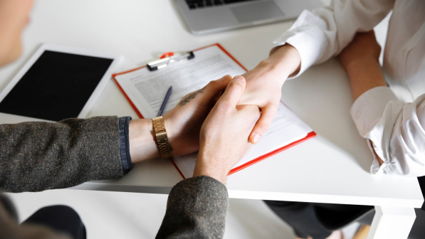 Close up of male and female hands holding at the table with sheets, laptop, phone, office. Helping, support, assistance, support, agreement. Romantic relationship, love or family concept. Work, job.
