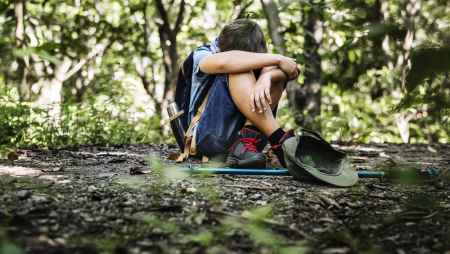 Boy lost and sad in the forest