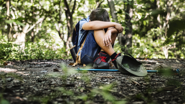 Boy lost and sad in the forest
