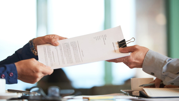 Business person giving partnership agreement to coworker