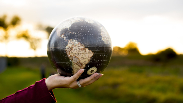 A closeup shot of a female holding a globe with a blurred background